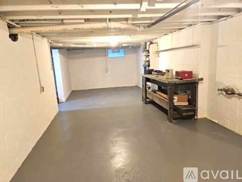 A spacious, empty room with a workbench and tools.