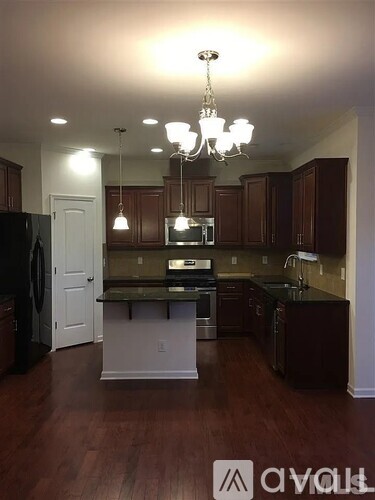 A kitchen with dark wood cabinets and a white island.