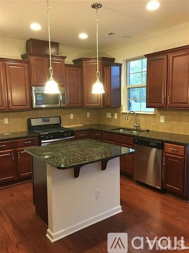 A kitchen with brown cabinets and a granite counter top.