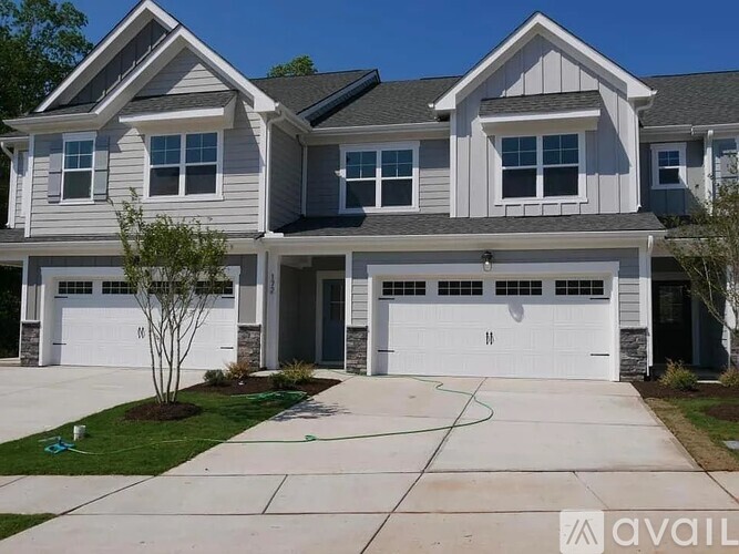 A two-story house with a garage and a driveway.
