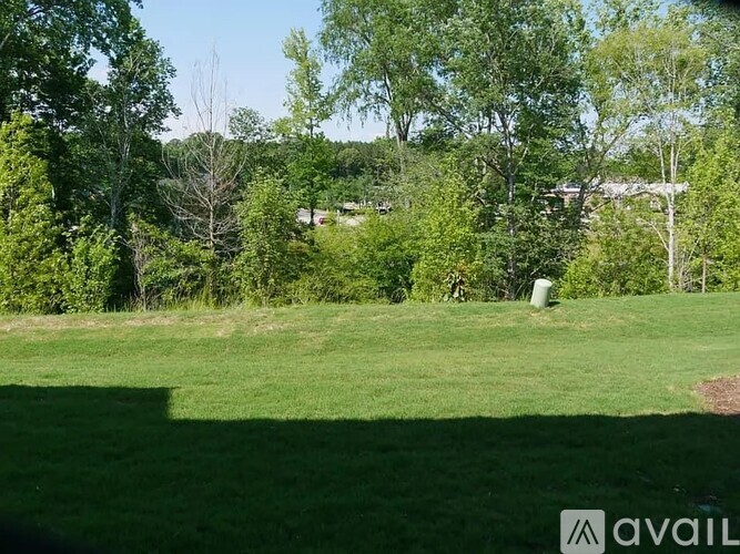 A grassy field with trees in the background and a watermark in the bottom right corner.