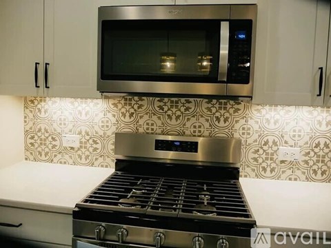A modern kitchen with a stove and microwave above it.