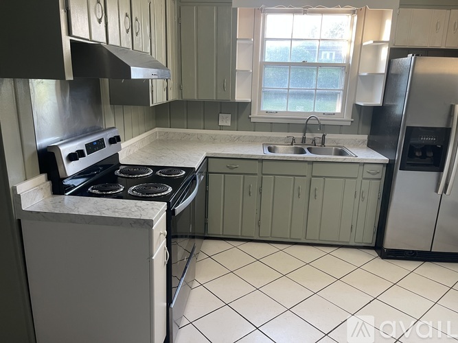 A kitchen with a stove top oven and a refrigerator.