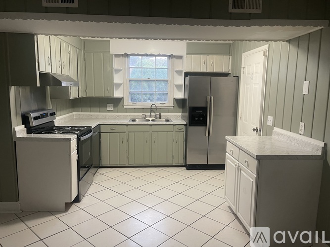 A kitchen with white appliances and cabinets.