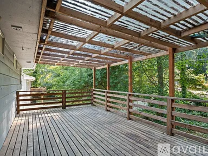 A wooden deck with a roof and railings.