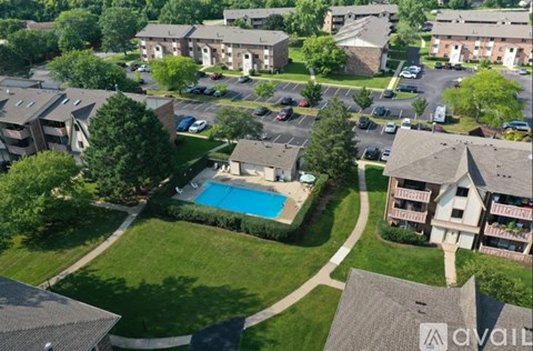 A bird's eye view of a residential area with houses, cars, and a swimming pool.