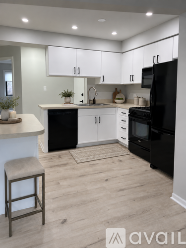 A kitchen with black appliances and white cabinets.