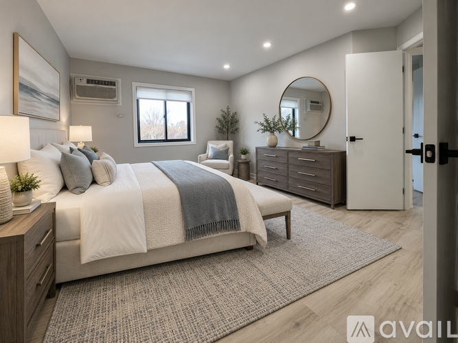 A well-lit bedroom with a large bed, a mirror, and a dresser.