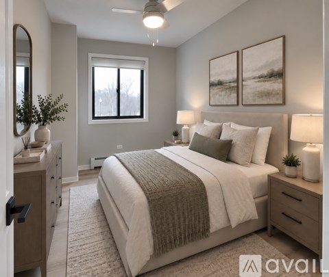 A well-lit bedroom with a large bed and a painting on the wall.