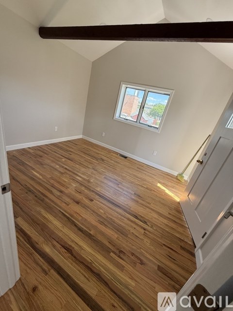 A room with wooden flooring and a window.
