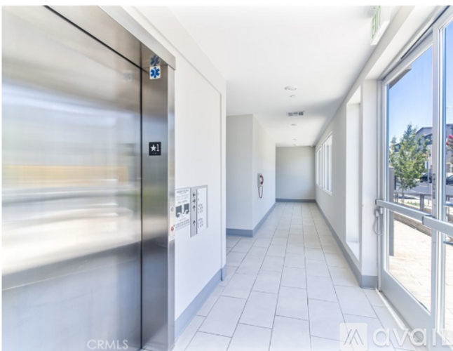 A long hallway with a glass door on the left and a glass door on the right.