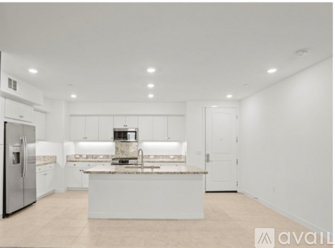 A modern kitchen with white appliances and cabinets.