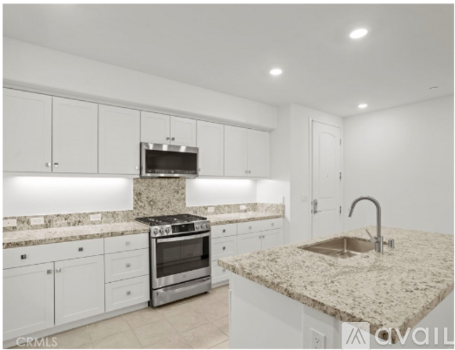 A kitchen with granite countertops and stainless steel appliances.