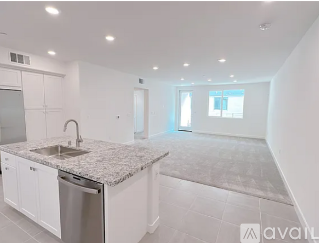 A kitchen with a granite countertop and stainless steel dishwasher.