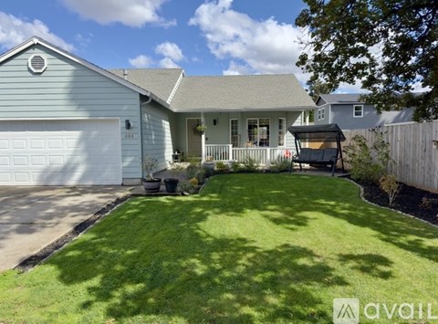 A house with a well-maintained lawn and a covered patio area.