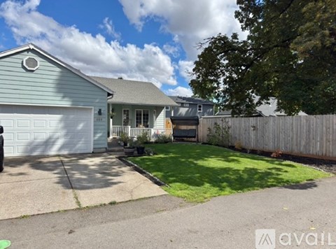 A house with a garage and a fence in front of it.