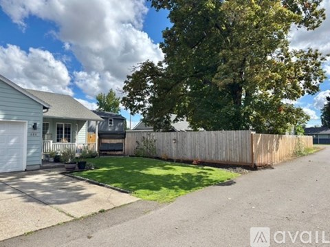 A house with a driveway and a tree in front.