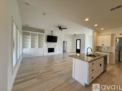 A spacious kitchen with a central island and a television above it.