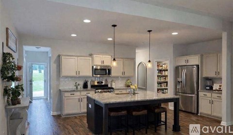 A kitchen with a center island and pendant lights.