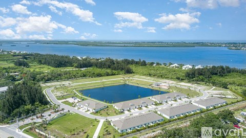 A large open area with a lake and buildings in the distance.