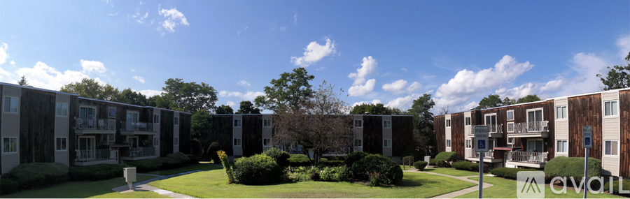 A row of apartment buildings with a grassy area in front.