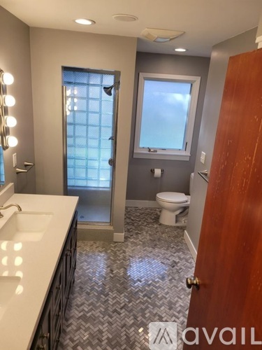 A bathroom with a sink, toilet, and a mirror.