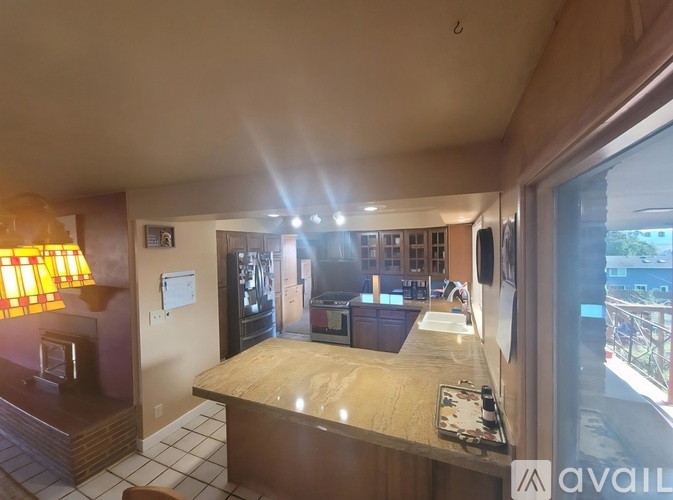A well-lit kitchen with a counter and a window.