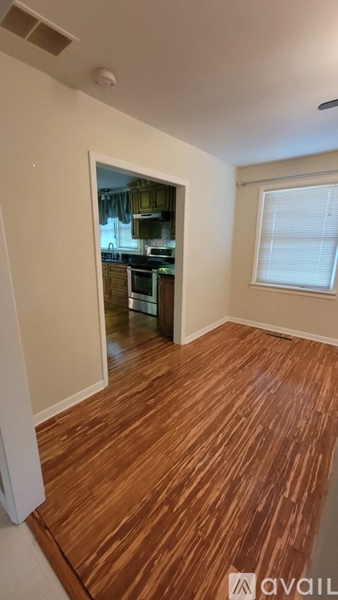 A room with wooden flooring and a window.