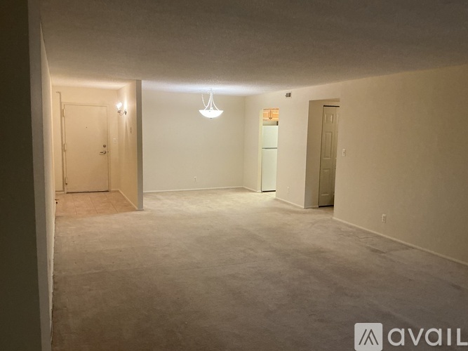 A spacious room with a carpeted floor and two doors.