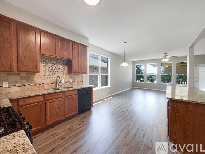 A kitchen with wooden cabinets and a granite countertop.