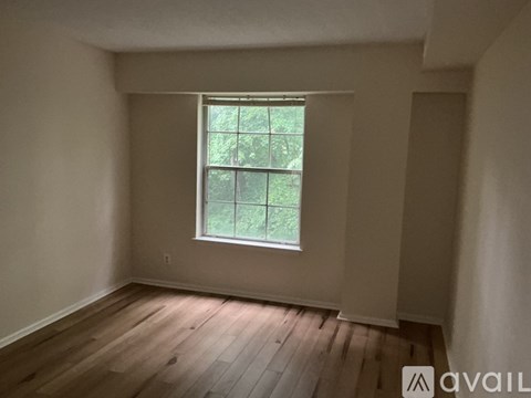A room with a window and wooden flooring.