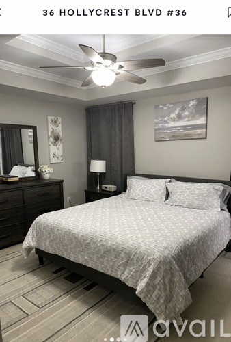 A bedroom with a bed, dresser, and ceiling fan.