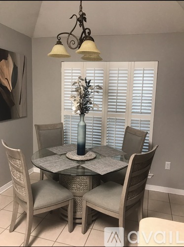A dining room with a glass table and chairs.