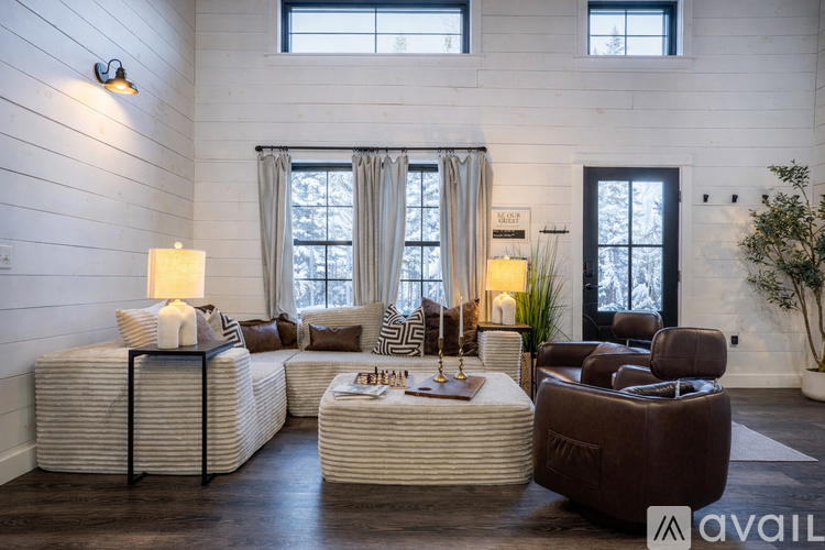 A living room with a white couch, a brown chair, and a coffee table.
