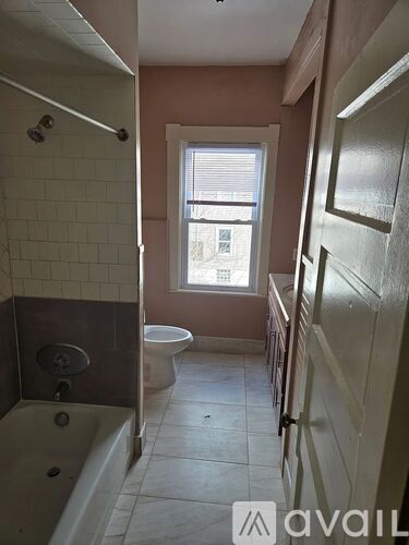 A bathroom with a tub, toilet, and sink.