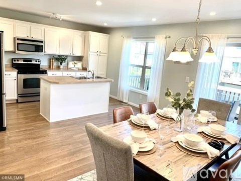 A kitchen with a dining table set for a meal.