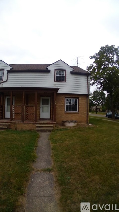A house with a white and brown exterior and a brown door.