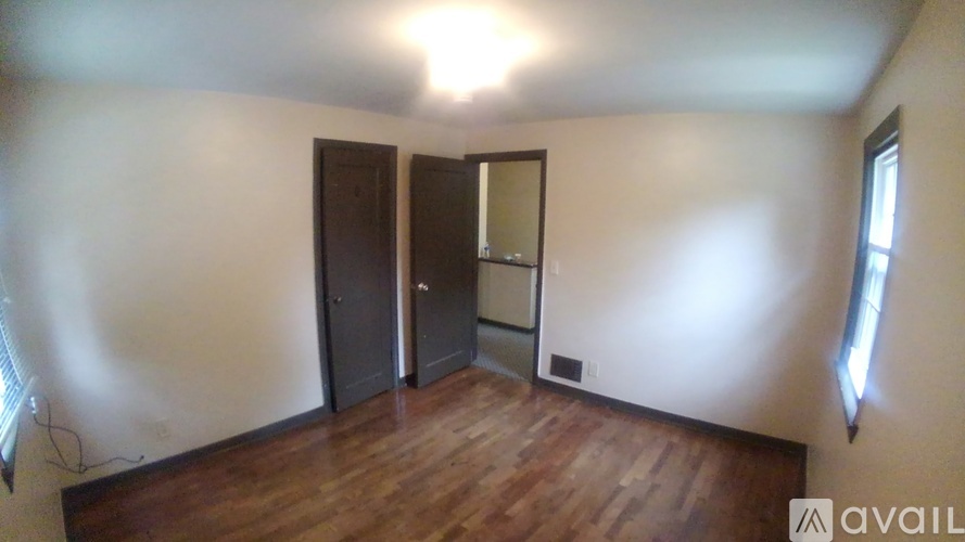 A room with wooden floors and a large mirror on the wall.