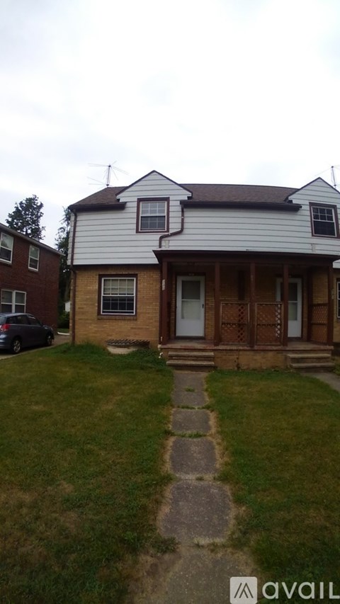 A house with a white and grey exterior and a brown door.