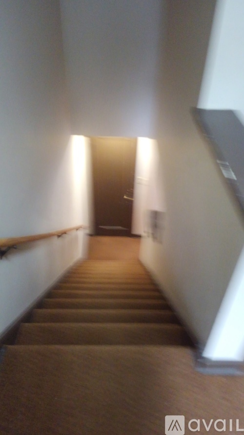 A long hallway with a carpeted floor and a light at the end.