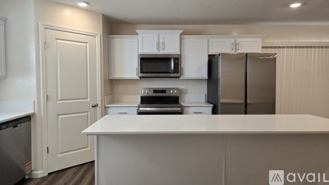 A kitchen with white cabinets and appliances is available for rent.
