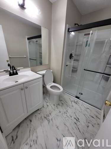 A bathroom with a marble floor and a walk-in shower.