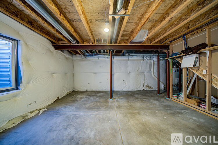 A room under construction with exposed wooden beams and unfinished walls.