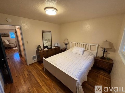 A bedroom with a bed, nightstands, and a mirror.