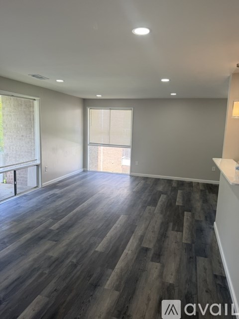 A room with wooden flooring and a window.