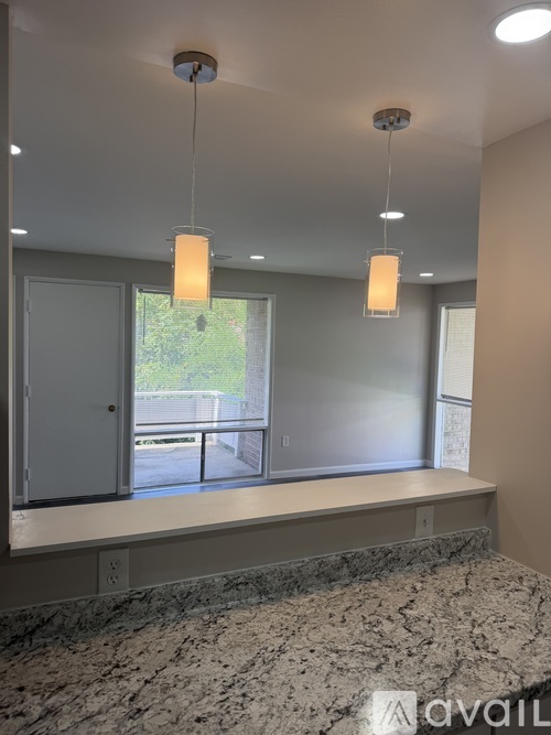 A room with a marble floor and a window overlooking a parking lot.