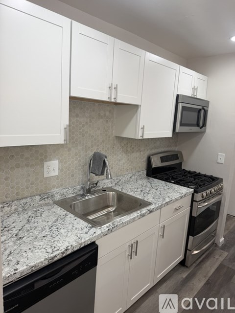 A kitchen with white cabinets and a granite countertop.
