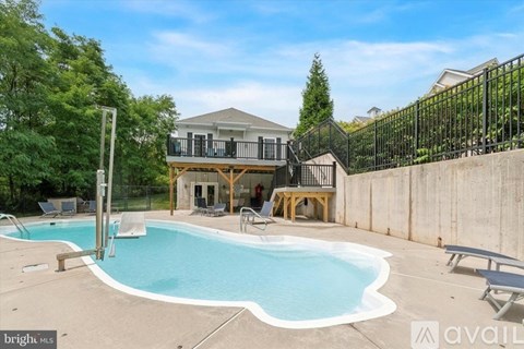 A brightly lit pool area with a house in the background.
