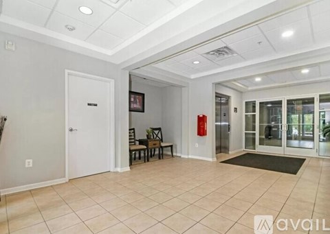 A spacious room with a fire extinguisher on the wall.
