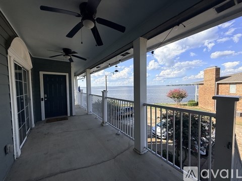 A balcony with a ceiling fan and a view of the water.